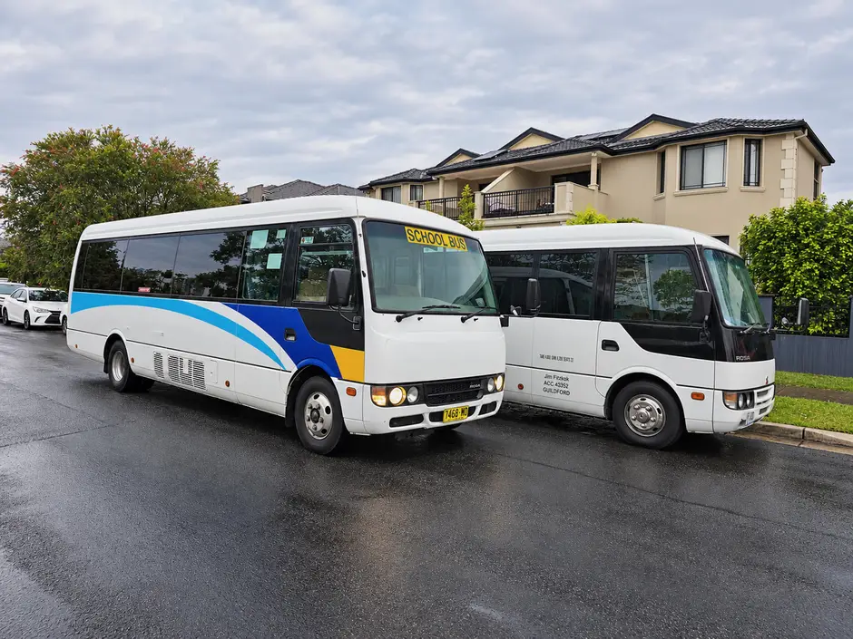 Two white minibuses on a street.